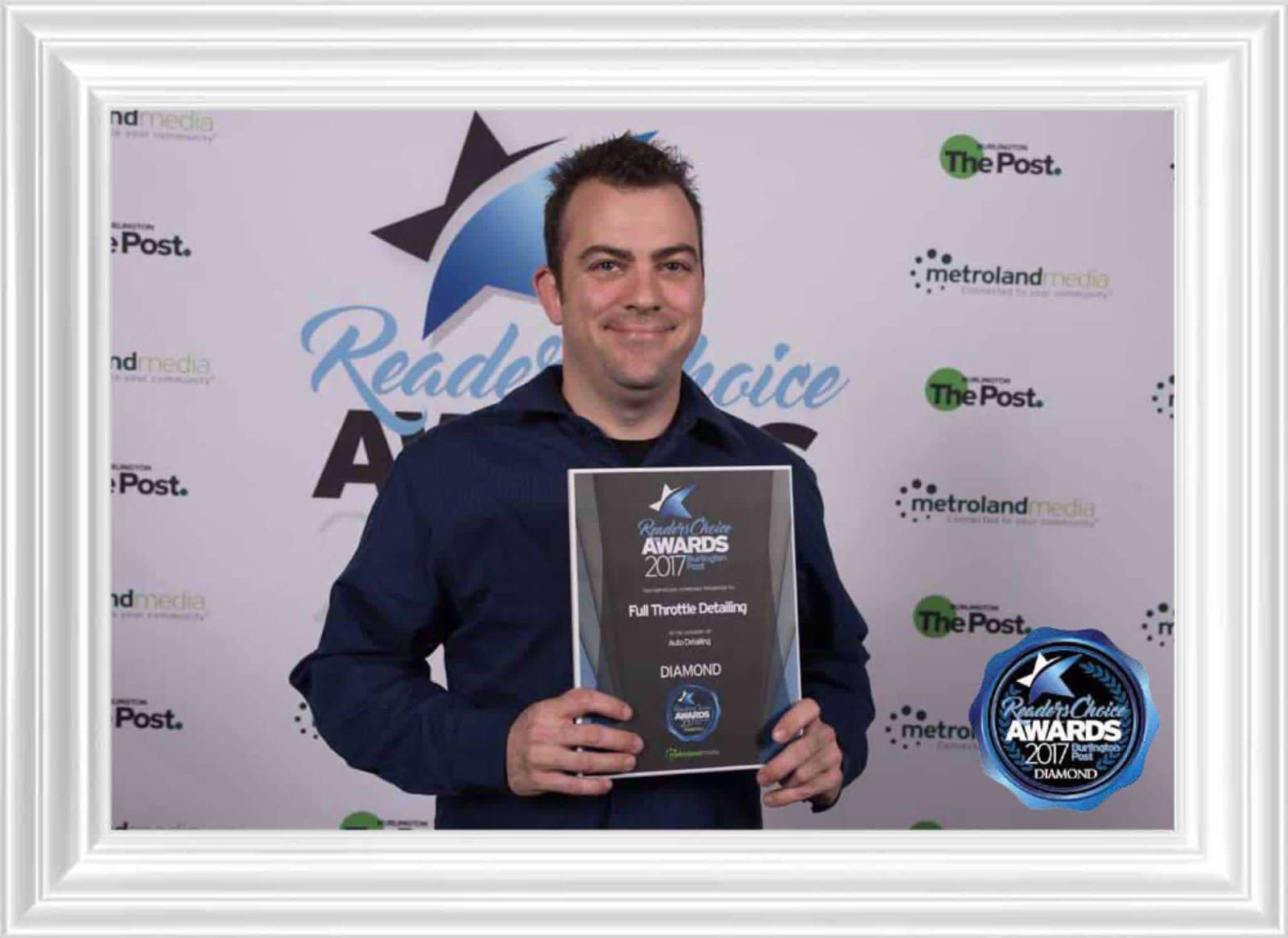 Gordon Gibson, owner of Classic 57 Auto Detailing, holding a Reader's Choice Diamond Award